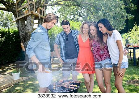 Groupe of happy and cheerful young people having fun around barbecue grill during summer holiday party outdoor in the garden. View Large Photo Image Stock Image - Groupe of happy and cheerful young people having fun around barbecue grill during summer holiday party outdoor in the garden.. Fotosearch