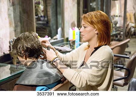 Stock Image - Hairdresser doing haircut. Fotosearch