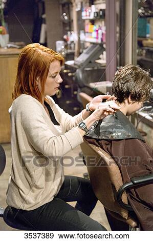 Stock Photo - Hairdresser doing haircut. Fotosearch