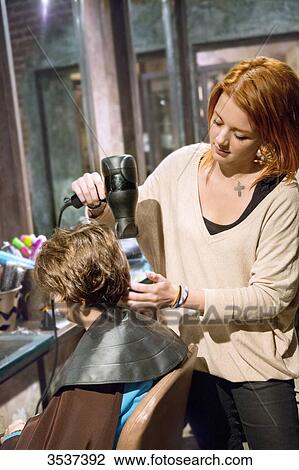 Hairdresser drying the hair of a boy View Large Photo Image Stock Image - Hairdresser drying the hair of a boy. Fotosearch