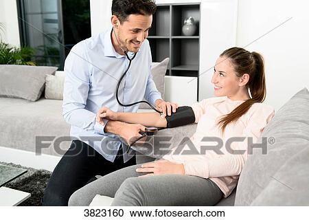 handsome young doctor visiting a woman patient at home View Large Photo Image Stock Image - handsome young doctor visiting a woman patient at home. Fotosearch