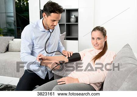 handsome young doctor visiting a woman patient at home View Large Photo Image Stock Image - handsome young doctor visiting a woman patient at home. Fotosearch