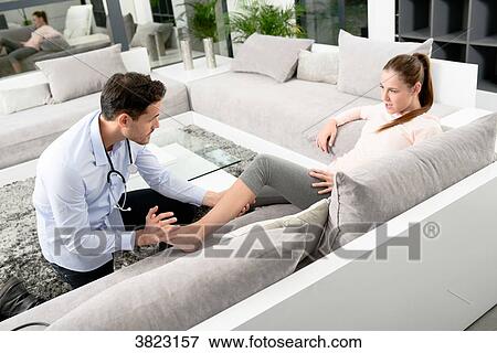 handsome young doctor visiting a woman patient at home View Large Photo Image Stock Photo - handsome young doctor visiting a woman patient at home. Fotosearch