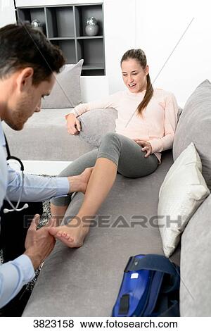 handsome young doctor visiting a woman patient at home View Large Photo Image Stock Photo - handsome young doctor visiting a woman patient at home. Fotosearch