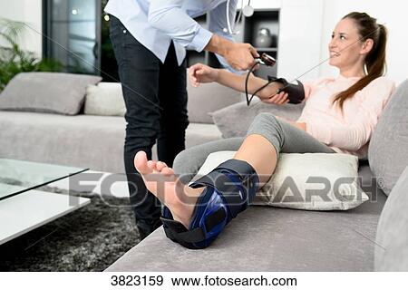 handsome young doctor visiting a woman patient at home View Large Photo Image Stock Photo - handsome young doctor visiting a woman patient at home. Fotosearch