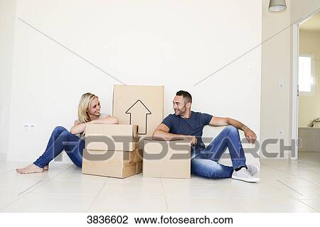 Happy young couple carrying cardboard boxes and moving into their new house. View Large Photo Image Stock Image - Happy young couple carrying cardboard boxes and moving into their new house.. Fotosearch