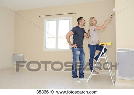 Happy young couple renovating painting and moving into their new house. View Large Photo Image Stock Image - Happy young couple renovating painting and moving into their new house.. Fotosearch