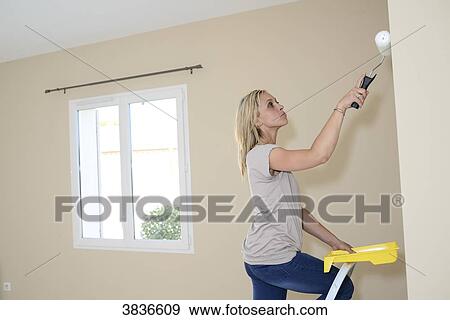 Happy young couple renovating painting and moving into their new house. View Large Photo Image Stock Photo - Happy young couple renovating painting and moving into their new house.. Fotosearch