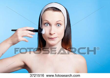 Humorous portrait of a woman using a makeup brush on face View Large Photo Image Stock Photograph - Humorous portrait of a woman using a makeup brush on face. Fotosearch