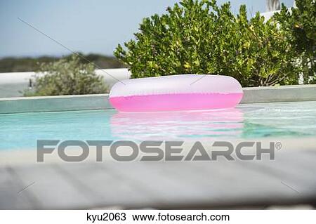 Stock Image - Inflatable ring floating on water in a swimming pool. Fotosearch
