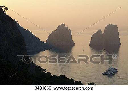 Italy, Amalfi Coast, Capri, Sunset on the Faraglioni. The Faraglioni are Capri's 3 mythical rocks. Seen from the Marina Piccola View Large Photo Image Stock Image - Italy, Amalfi Coast, Capri, Sunset on the Faraglioni. The Faraglioni are Capri's 3 mythical rocks. Seen from the Marina Piccola. Fotosearch