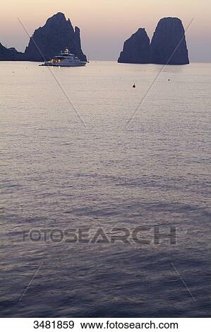 Italy, Amalfi Coast, Capri, Sunset on the Faraglioni. The Faraglioni are Capri's 3 mythical rocks. Seen from the Marina Piccola View Large Photo Image Stock Photo - Italy, Amalfi Coast, Capri, Sunset on the Faraglioni. The Faraglioni are Capri's 3 mythical rocks. Seen from the Marina Piccola. Fotosearch