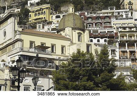Stock Photography - Italy, Amalfi Coast, Positano, old fishermen village built on a vertical axis and Santa Maria Assunta church with its dome covered in varnished tiles. Fotosearch