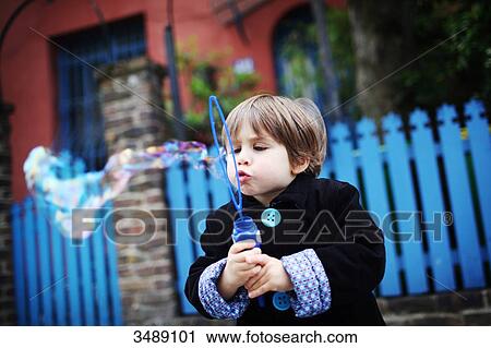 Little boy blowing bubbles in the street View Large Photo Image Stock Image - Little boy blowing bubbles in the street. Fotosearch