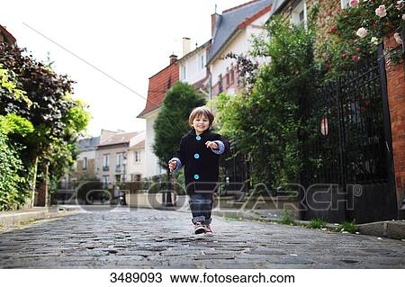 Little boy running in a cobbled narrow street View Large Photo Image Stock Image - Little boy running in a cobbled narrow street. Fotosearch