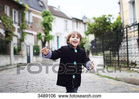 Little boy running in a cobbled narrow street View Large Photo Image Stock Photograph - Little boy running in a cobbled narrow street. Fotosearch