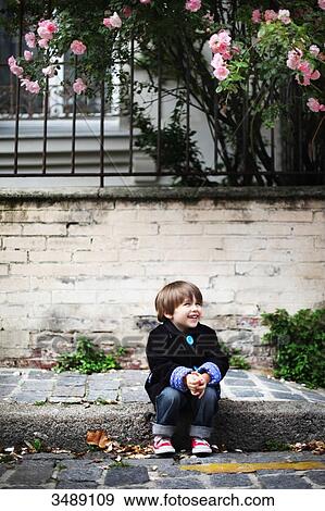 Stock Photo - Little boy sitting on the sidewalk. Fotosearch