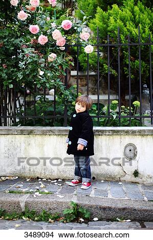 Picture - Little boy sulking in a cobbled narrow street. Fotosearch