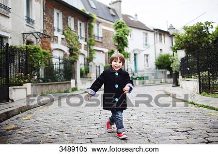 Stock Photography - Little boy walking in a cobbled narrow street. Fotosearch