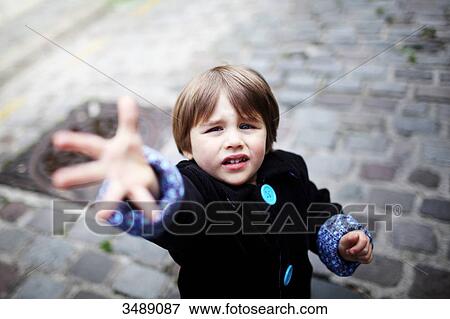 Stock Photo - Little boy with outstretched hand in the street. Fotosearch
