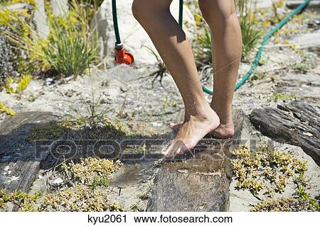 Stock Image - Low section view of a woman washing her feet. Fotosearch