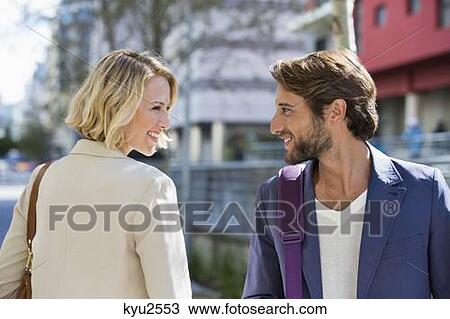 Stock Image - Man and woman smiling at each other. Fotosearch