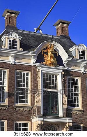 Stock Image - Netherlands, Friesland. Harlingen. Golden statue on the city hall facade.. Fotosearch