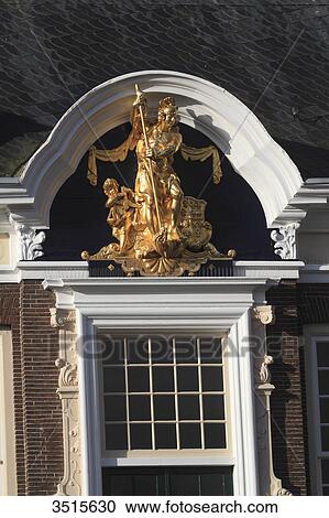 Stock Image - Netherlands, Friesland. Harlingen. Golden statue on the city hall facade.. Fotosearch