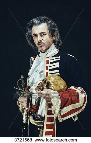Stock Photo - Officer in uniform dragons holds a skull and a sword in his hands. Fotosearch