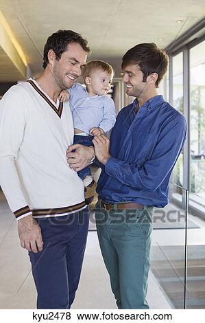 Stock Photo - Parents smiling with their son at home. Fotosearch