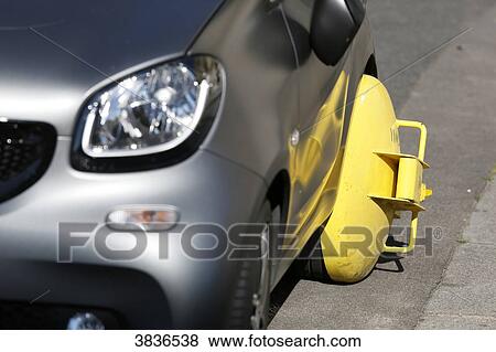 Stock Photo - Paris, 1st arrondissement. Car parked prohibited blocked by a hoof.. Fotosearch