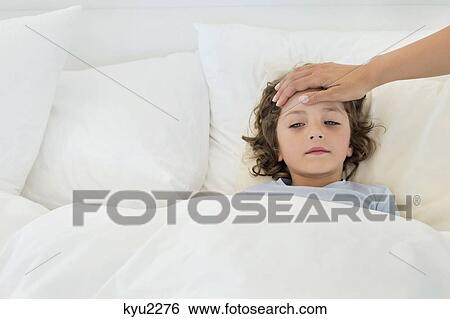 Person's hand examining fever of a boy View Large Photo Image Stock Photograph - Person's hand examining fever of a boy. Fotosearch