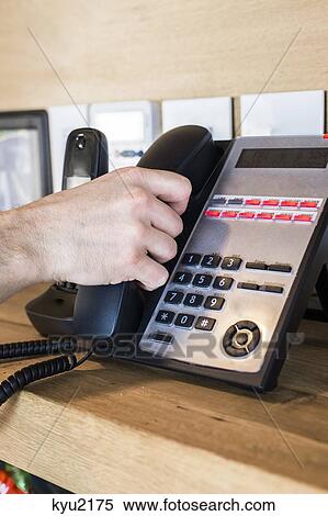Stock Photography - Person's hand picking telephone receiver. Fotosearch