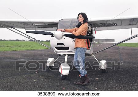Pilot young woman in front of her microlight on the runway. View Large Photo Image Stock Photo - Pilot young woman in front of her microlight on the runway.. Fotosearch