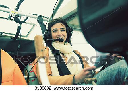 Stock Image - Pilot young woman in the cockpit of her microlight.. Fotosearch