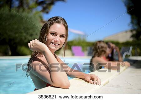 Portrait of a beautiful young woman in the poolside of a resort swimming pool during summer holiday. View Large Photo Image Stock Image - Portrait of a beautiful young woman in the poolside of a resort swimming pool during summer holiday.. Fotosearch