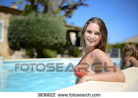Portrait of a beautiful young woman in the poolside of a resort swimming pool during summer holiday. View Large Photo Image Stock Image - Portrait of a beautiful young woman in the poolside of a resort swimming pool during summer holiday.. Fotosearch