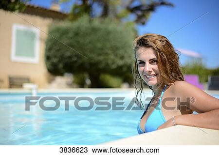 Portrait of a beautiful young woman in the poolside of a resort swimming pool during summer holiday. View Large Photo Image Stock Image - Portrait of a beautiful young woman in the poolside of a resort swimming pool during summer holiday.. Fotosearch