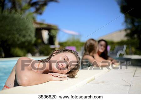 Portrait of a beautiful young woman eyes shut sunbathing by the poolside of a resort swimming pool during summer holiday. View Large Photo Image Stock Image - Portrait of a beautiful young woman eyes shut sunbathing by the poolside of a resort swimming pool during summer holiday.. Fotosearch