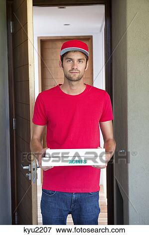 Stock Photo - Portrait of a deliveryman delivering pizza . Fotosearch