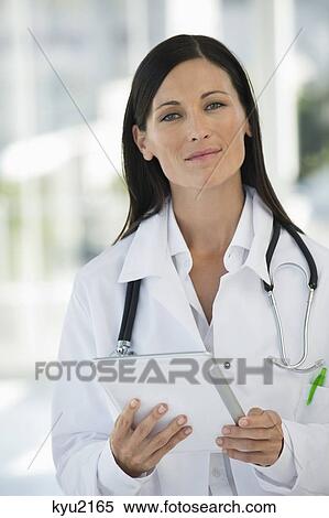 Portrait of a female doctor holding a digital tablet View Large Photo Image Stock Photography - Portrait of a female doctor holding a digital tablet. Fotosearch