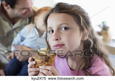 Stock Photography - Portrait of a girl eating bread. Fotosearch