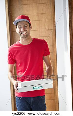 Stock Photograph - Portrait of a smiling deliveryman delivering pizza. Fotosearch