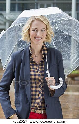 Portrait of a smiling woman with an umbrella View Large Photo Image Stock Photo - Portrait of a smiling woman with an umbrella. Fotosearch