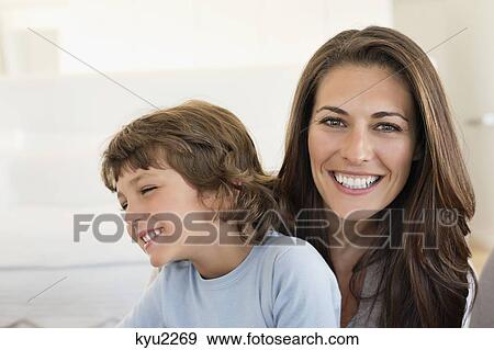Portrait of a woman and her son smiling View Large Photo Image Stock Photo - Portrait of a woman and her son smiling. Fotosearch