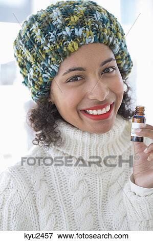 Stock Photo - Portrait of a woman holding a bottle and smiling. Fotosearch