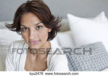 Portrait of a woman smiling while sitting on the bed View Large Photo Image Stock Photo - Portrait of a woman smiling while sitting on the bed. Fotosearch