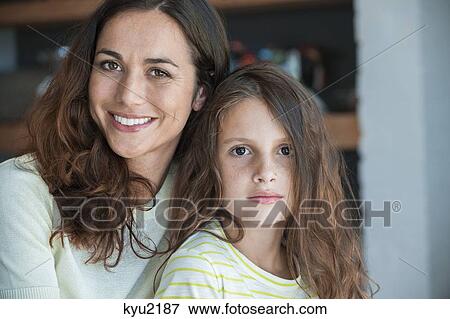 Portrait of a woman smiling with her daughter View Large Photo Image Stock Photo - Portrait of a woman smiling with her daughter. Fotosearch