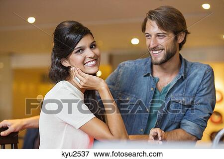 Stock Photo - Portrait of a woman smiling with her friend beside her. Fotosearch