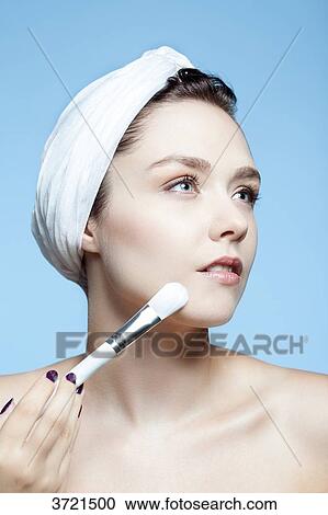 Portrait of a woman using make-up brush on face View Large Photo Image Stock Image - Portrait of a woman using make-up brush on face. Fotosearch